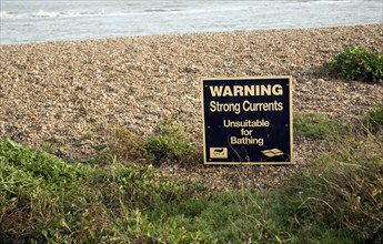 Sign warning of strong currents water unsuitable for bathing, Shingle Street, Suffolk, England, UK