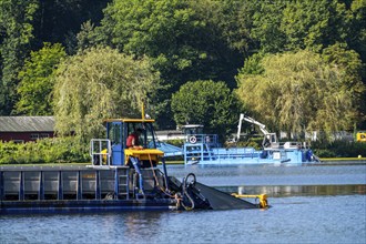 Mowing boats Nimmersatt and Berky, of the Ruhrverband, try to keep the green plant carpet on the