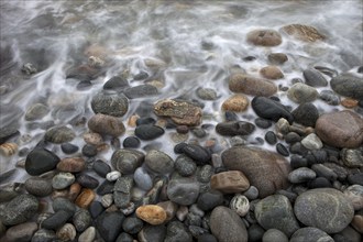 Stones on the beach with running water, Sommarøy, Norway, Europe