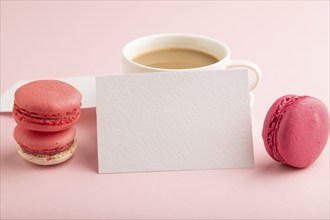 White paper business card mockup with red and purple macaroons and cup of coffee on pink pastel