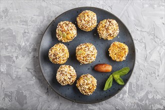 Energy ball cakes with dried apricots, sesame, linen, walnuts and dates with green mint leaves on a