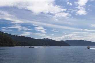 Blue sea with boats and blue sky with clouds