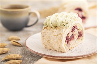 Roll biscuit cake with cream cheese and jam, cup of coffee on brown concrete background and orange