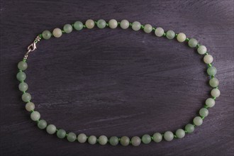 Green agate colored beads on a black background. top view, close up