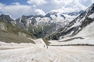 Mountaineers hiking in a snowfield, Nördliche Mörchnerscharte, behind mountain peak Kleiner