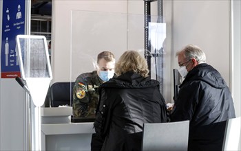 Bundeswehr soldiers help with the registration of vaccinees in front of their booster vaccination