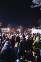 Tightly packed crowd celebrates carnival at night in winter, carnival, Schellbronn night parade,