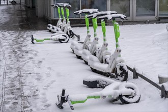 Winter in the city, snow-covered e-scooters from On Lime Uber, Gallusanlage, Frankfurt am Main,