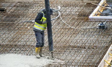 Construction site, concreting, the floor slab of a building is concreted, the concrete is pumped