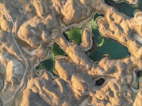 Green lakes between golden hills with gravel road, top down shot, aerial view, Trans Alay