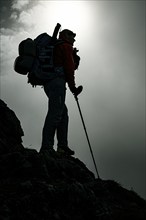 Mountaineer with luggage in the background Rätikon mountains with cloudy sky, Tschagguns, Rätikon,