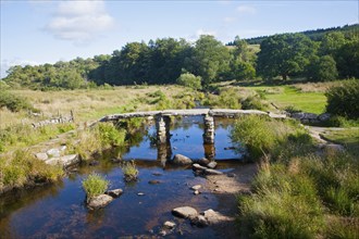 Historic medieval Clapper Bridge at Postbridge, Dartmoor national park, Devon, England crossing the