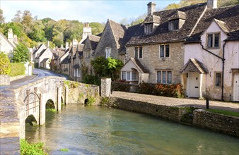 Bybrook River running past stone cottages in Castle Combe, Wiltshire, England, UK claimed to be