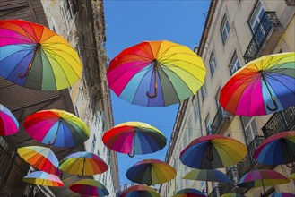 Hanging colourful umbrella installation between buildings on a sunny day, Pink Street, Rua Nova do