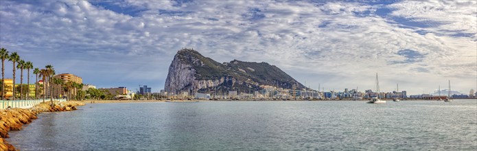 Panoramic view of a coastal town with a prominent rock and cloudy sky, Gibraltar, Europe