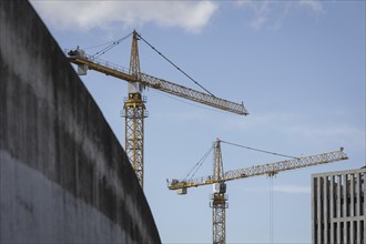 Two construction cranes in front of a blue sky in the Mitte district of Berlin, 28/03/2024