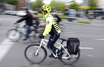 A policewoman from the Berlin bicycle squadron accompanies the bike parade demonstration, Berlin,