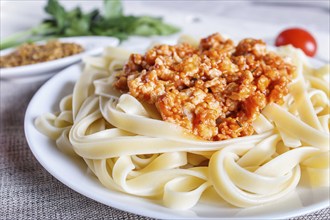 Fettuccine bolognese pasta with minced meat on white wooden background. top view, close up