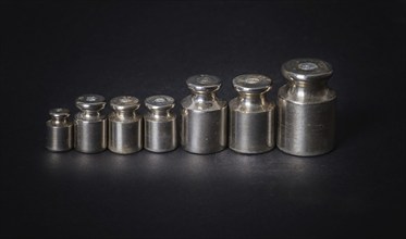 A set of small metal weights on a gray background