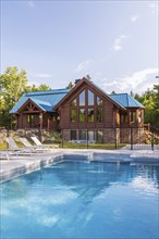 In-ground salt water swimming pool and brown stained milled Eastern white pine timber and flat log