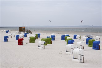 Beach chairs on the sandy beach, DLRG watchtower, kitesurfer on the North Sea, Utersum, Föhr, North