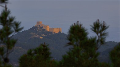 A castle on a hill in the first morning light, surrounded by trees at dusk, Kritinia Castle, St