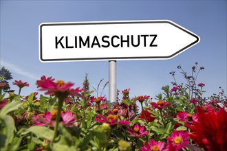 Climate protection symbol: flowers against a blue sky, with the word CLIMATE PROTECTION on an arrow