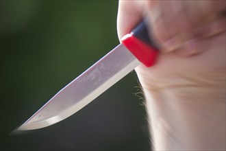 Symbolic image of a knife attack: close-up of a knife in a man's hand