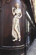 Scantily clad young woman as a facade decoration on a shop in Karlsgasse, Old Town, Prague, Czech