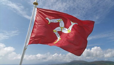 The flag of the Isle of Man, Great Britain, flutters in the wind