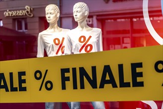 Sale, shop window with advertisement for discounts, percentages, clothing, mannequins, reduced,