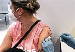 A woman receives a booster vaccination from Moderna against Covid 19 at the Schönefeld vaccination