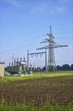 Substation with high-voltage pylon in agricultural landscape near Beckdorf, district of Stade,