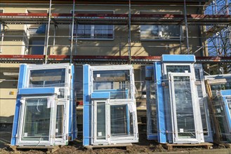 Energy-efficient refurbishment of residential buildings, older apartment block is scaffolded, gets