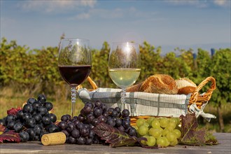 Symbolic image: Ripe grapes decorated with wine glasses on a wooden table