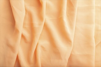 Fragment of orange linen tissue. Top view, natural textile background and texture. wave concept,