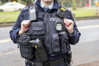 Police, policewoman with equipment waistcoat, CO measuring device device, above a bodycam, first