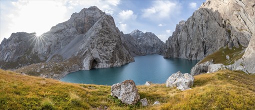 Mountain lake Kol Suu with rocky steep mountains, Sun Star, Kol Suu Lake, Sary Beles Mountains,