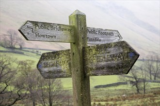 Wooden footpath pointer signpost at Howtown, Lake District national park, Cumbria, England, UK