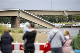 Passers-by look at the partially collapsed Carola Bridge from the Königsufer in Dresden, 11/09/2024