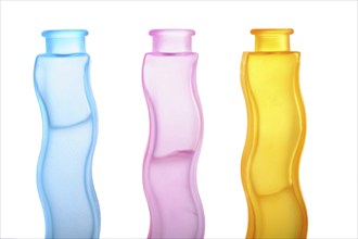 Three glass bottles with coloured liquid, studio