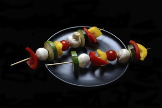 Colourful vegetable skewers on a plate, barbecue skewers