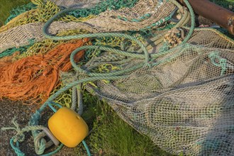 Fishing nets, ropes and floats lying in a meadow, Greetsiel, Krummhörn, East Frisia, Lower Saxony,