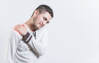 Person with shoulder muscle pain on isolated background. Unhappy man with shoulder pain isolated