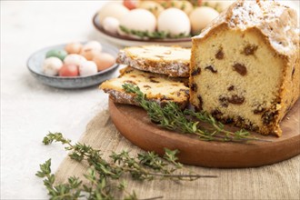 Homemade easter pie with raisins and eggs on plate on a gray concrete background and linen textile.