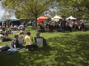 People watching a brass band perform during a country fair, Helmingham Hall, Suffolk, England,