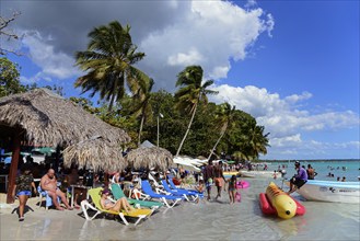 Holidaymakers spending time on the beach with inflatable toys in the water, Boca Chica, Santo