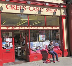 Boy busking playing tin whistle outside shop, Youghal, County Cork, Ireland, Irish Republic, Europe