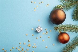 Christmas or New Year composition. Decorations, bronze balls, fir and spruce branches, on a blue