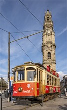 The iconic red tram number 18 pauses in front of the Clérigos Church Tower, Porto, Portugal, Europe